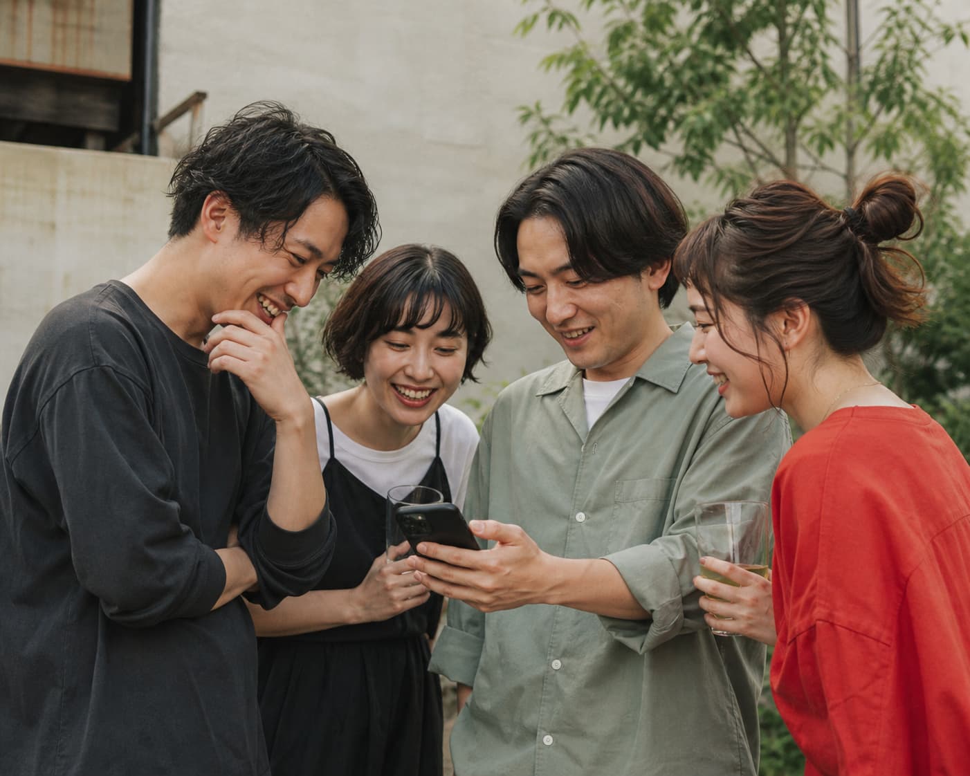 友達同士でスマートフォンの写真を一緒に見る様子